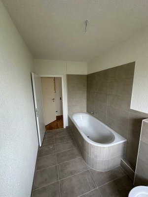 Erstbezug nach Sanierung mit Balkon und Einbauküche: Geschmackvolle 3-Zimmer-DG-Wohnung