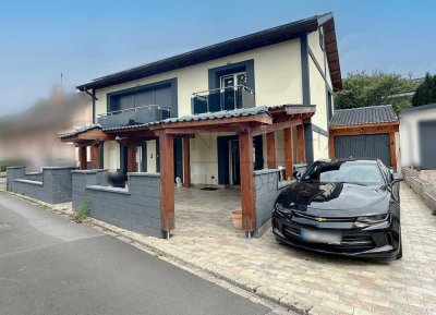 Stilvolles Einfamilienhaus mit Garten, Garage und großer Terrasse.